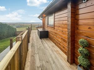 a wooden deck with a bench on the side of a house at Coo Lodge - Uk48430 in Falkirk