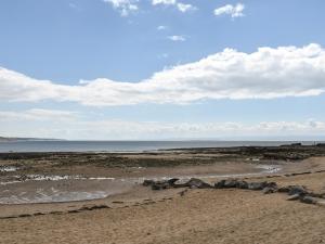 a beach with rocks on the sand and the ocean at Secret Spot in Newton