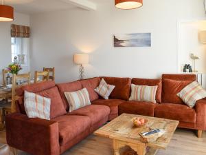 a living room with a brown couch and a table at Harbourside Apartment in Anstruther