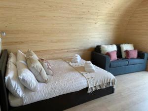 a bedroom with a bed and a blue couch at Foty - Uk2781 in Llanelidan +5 photos