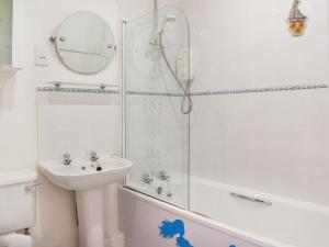 a white bathroom with a sink and a shower at Chy Morvoren in Falmouth