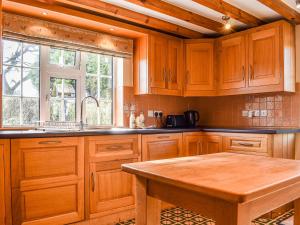 a kitchen with wooden cabinets and a wooden table at Hollywell Cottages in Clifton +16 photos