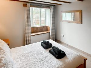 a bedroom with a bed with two black pillows on it at Old Kielder Castle Cottage in Kielder +18 photos