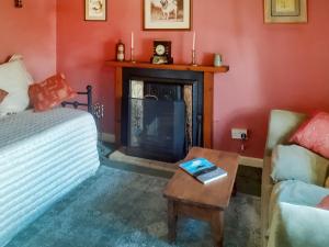 a living room with a couch and a fireplace at Pencaire in Helston