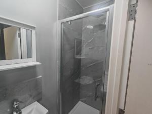 a shower with a glass door in a bathroom at 151 Felixstowe road in Edmonton