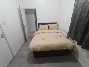 a small bedroom with a bed in a white room at 151 Felixstowe road in Edmonton