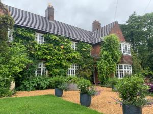 an old house with trees and plants in the yard at Banksiae in Tackley