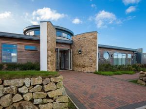 a house with a stone wall and a brick driveway at Aquamarine in Carbis Bay