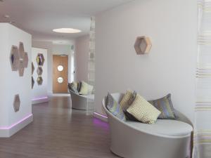 a living room with a white couch and chairs at Aquamarine in Carbis Bay