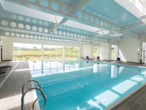 a large swimming pool with blue water in a building at Aquamarine in Carbis Bay