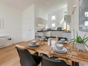 a dining room with a wooden table and chairs at Aquamarine in Carbis Bay +32 photos