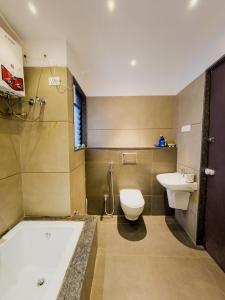 Un baño con bañera, inodoro y lavabo. en Luxury Retreat Villa, en Kolhapur