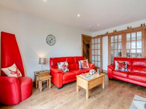 a living room with two red couches and a table at Clunnie Mor - S4615 in Aviemore