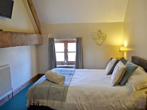 a bedroom with a large bed and a window at Shire Cottage in Sewerby