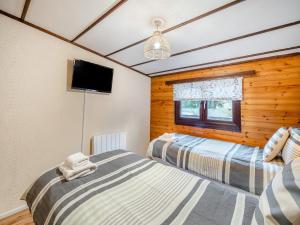 une chambre avec deux lits et une télévision à écran plat dans l'établissement Seathwaite Tarn, à Ambleside 15 autres photos
