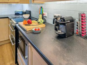 a kitchen with a counter top with vegetables on it at Saddlers Cottage in Gattonside +15 photos
