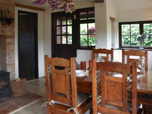 une salle à manger avec une table et des chaises en bois dans l'établissement Capri Cottage, à Winterton-on-Sea