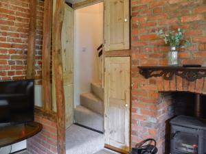 une porte ouverte dans une pièce en briques avec un escalier dans l'établissement Capri Cottage, à Winterton-on-Sea