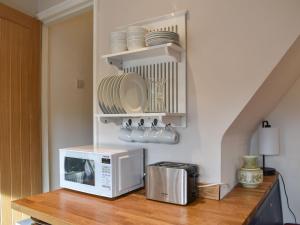 a microwave sitting on a wooden counter in a kitchen at Vine Cottages in Crich +13 photos