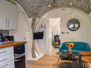 a kitchen and living room with a table and chairs at The Hobbit House in Hastingleigh