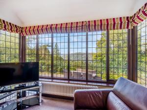 a living room with a couch and a large window at High Biggin in Windermere