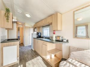 a kitchen with wooden cabinets and a counter top at Vanhalla in Morecambe