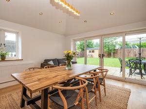 een eetkamer met een houten tafel en stoelen bij Clematis Cottage in Thorpe Market +30 foto's