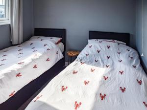 zwei Betten mit roten Blumen darauf in einem Schlafzimmer in der Unterkunft Harley's Beach House in Scratby + 7 Fotos