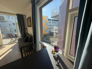 ein Wohnzimmer mit einem Tisch und einem Fenster mit Aussicht in der Unterkunft JR apartments in Reykjavík