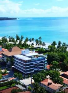 a view of a building with the ocean in the background at Hoa Beach Flat 205 in Tamandaré
