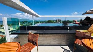a patio with chairs and a swimming pool at Hoa Beach Flat 205 in Tamandaré +5 photos