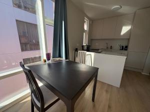eine Küche mit einem schwarzen Tisch, einem Tisch und Stühlen in der Unterkunft JR apartments in Reykjavík