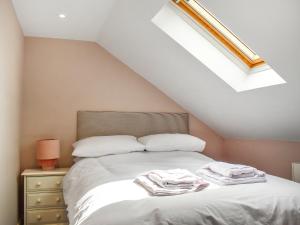 ein Schlafzimmer mit einem Bett mit weißen Laken und Kissen in der Unterkunft Swift Cottage - Uk47527 in Roxby