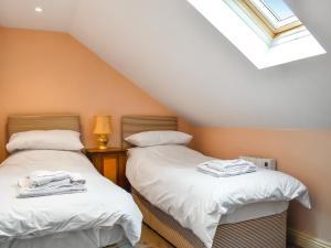 2 Einzelbetten in einem Dachzimmer mit Fenster in der Unterkunft Swift Cottage - Uk47527 in Roxby + 6 Fotos