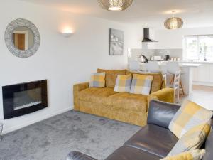 a living room with a couch and a fireplace at Beach Cottage in Benllech
