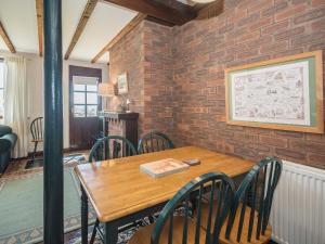 a dining room with a wooden table and chairs at Meadowsweet Cottage - E1496 in Scalby