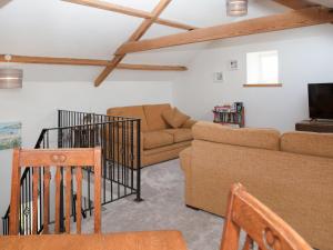 a living room with a couch and a tv at Criffel Cottage in Ruthwell