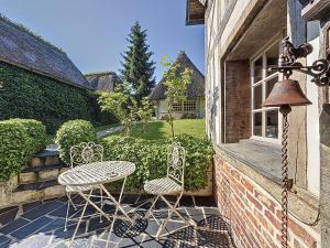 two chairs and a table on the porch of a house at la chaumière de Vieux Port in Vieux-Port