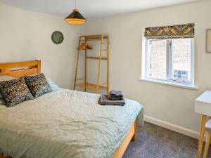 une chambre avec un lit et une fenêtre dans l'établissement Curiosity Cottage, à Eyam 14 autres photos
