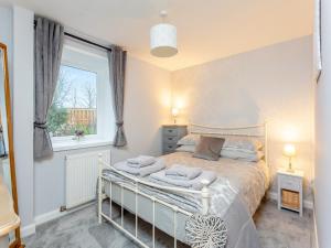 une chambre avec un lit et une fenêtre dans l'établissement East Tarrel Cottage, à Portmahomack