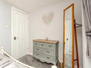 une chambre avec une commode et un miroir dans l'établissement East Tarrel Cottage, à Portmahomack