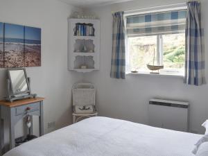 a bedroom with a bed and a window at Garden Cottage - Uk30590 in Polperro