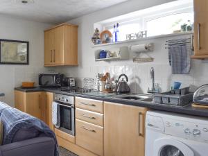 a kitchen with a sink and a washing machine at Garden Cottage - Uk30590 in Polperro