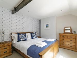 a bedroom with a bed and a wooden dresser at Pinfold Cottage in Richmond