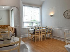Un comedor con mesa y sillas y una ventana. en Drumford, en Blackpool