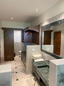 曼达瓦Aangan Resort的一间带大理石台面和镜子的浴室