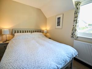 ein Schlafzimmer mit einem Bett und einem Fenster in der Unterkunft The Yellow House in Padstow