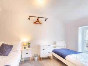 a bedroom with two beds and a dresser at Raven Cottage in Barnard Castle