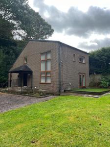 a brick house with a grassy yard in front of it at Dunsdale Lodge in Frodsham