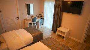 a small hotel room with a bed and a desk at Beyaz Ev Otel Restaurant in Eskiömerler
